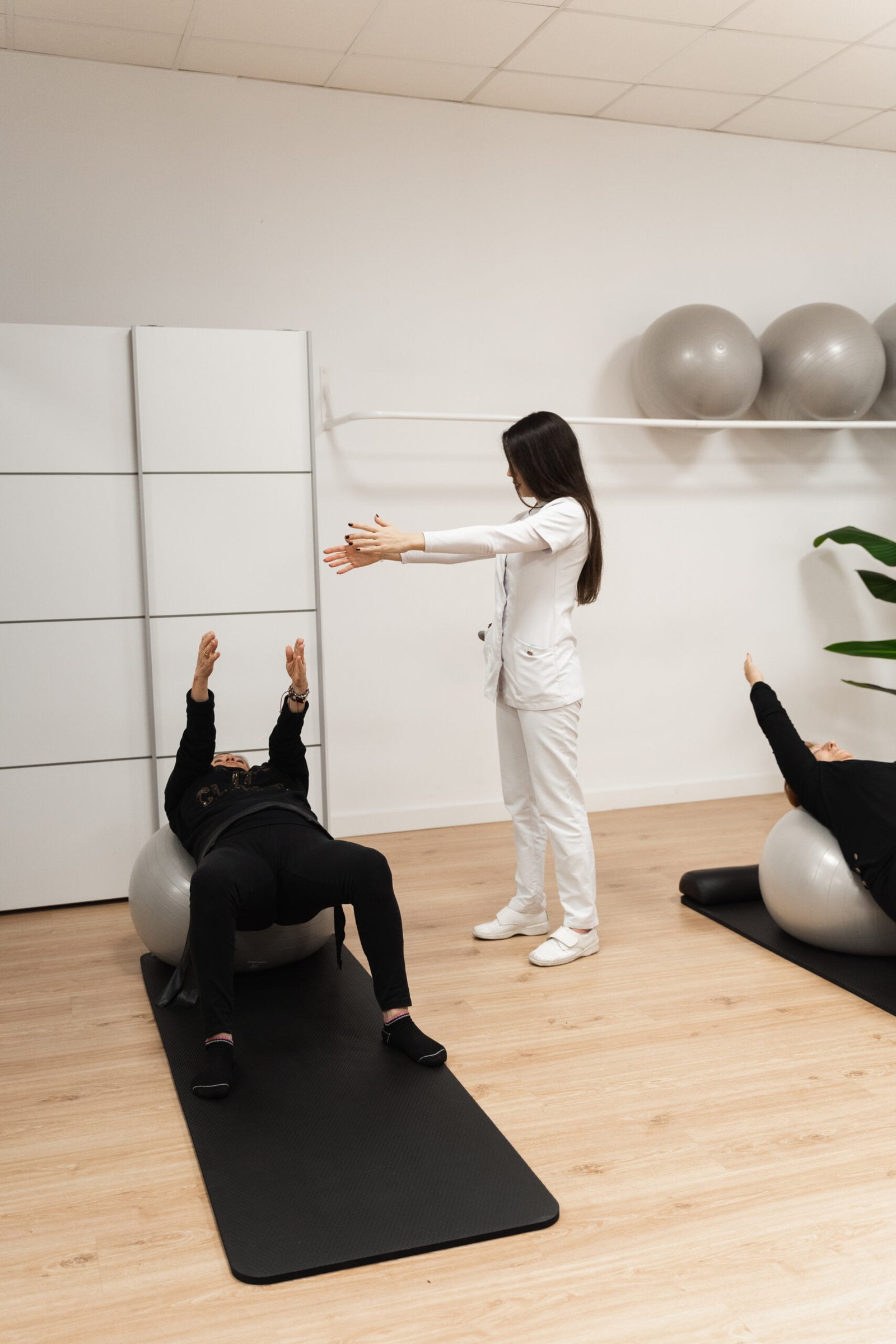 La fisioterapeuta Laura Bracero enseñando a realizar bien a una paciente ejercicios de pilates en una de sus clases de pilates terapéutico.