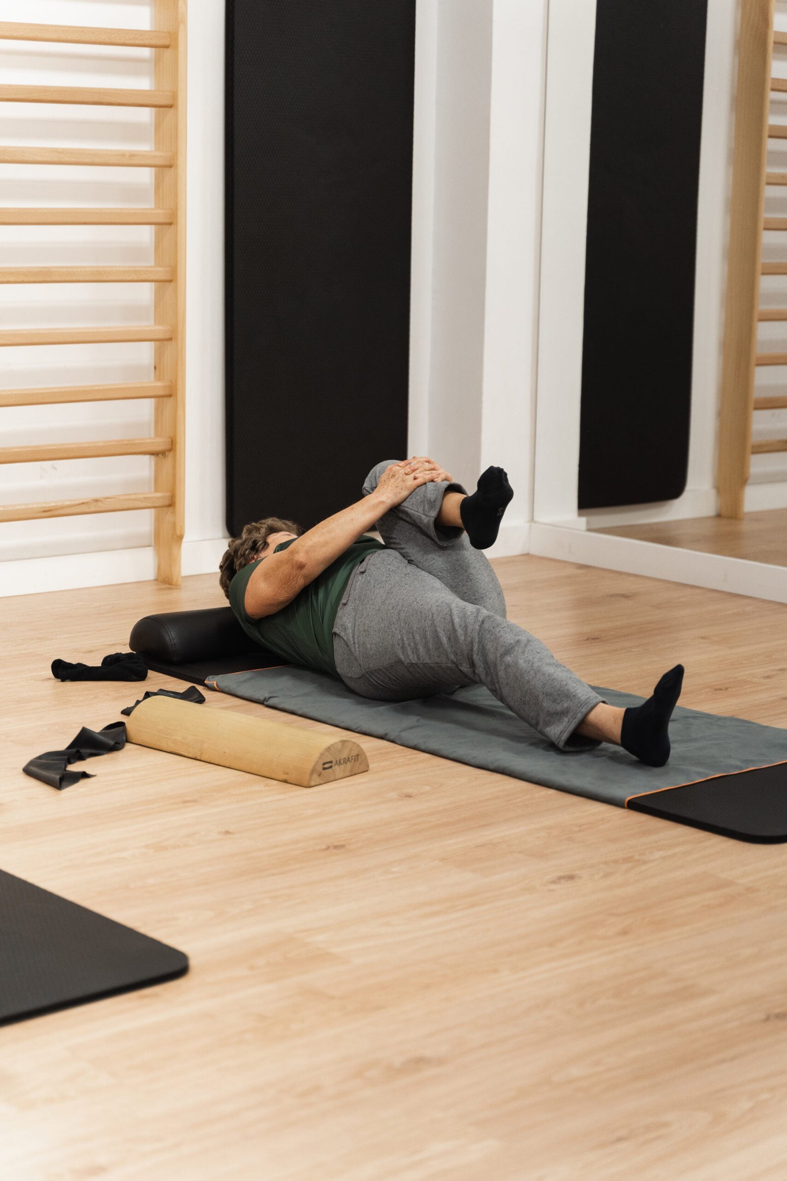 Persona realizando un estiramiento en una clase de pilates terapéutico de Equilibrio Fisioterapia.