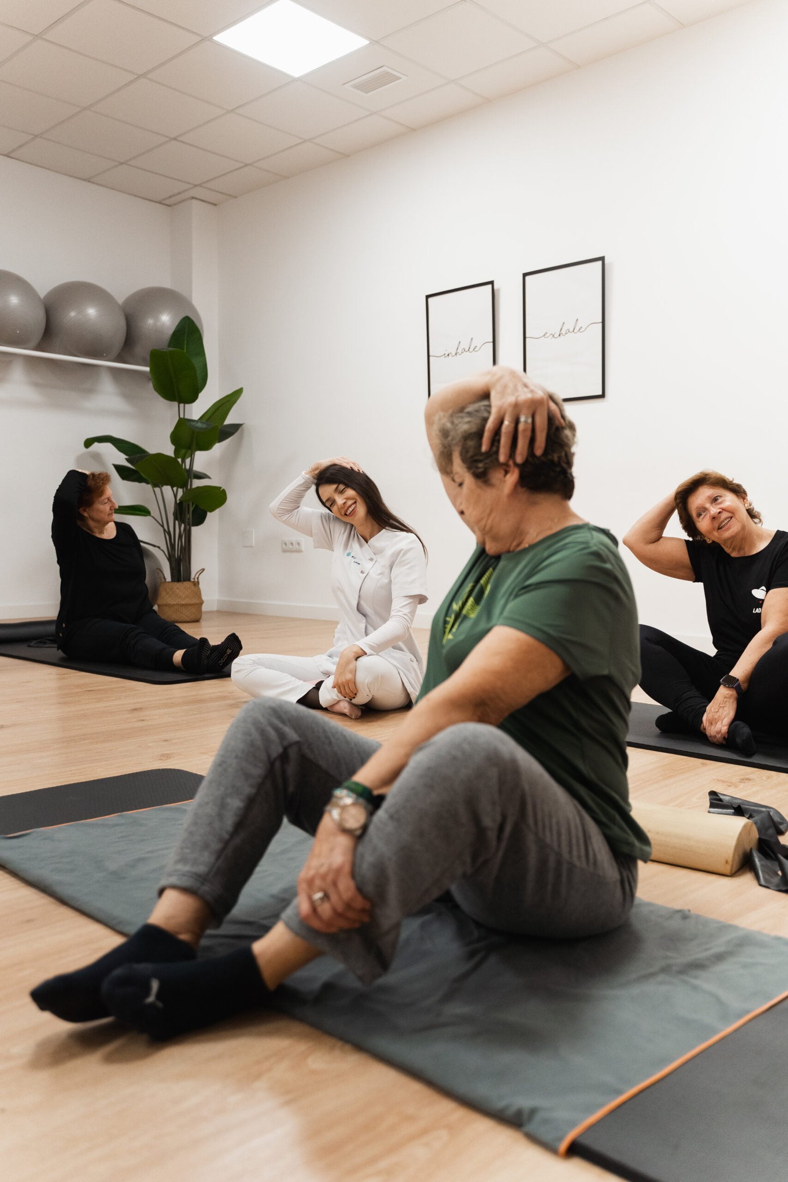 La fisioterapeuta Laura Bracero realizando estiramientos de cuello en una de sus clases de pilates terapéutico con sus pacientes.