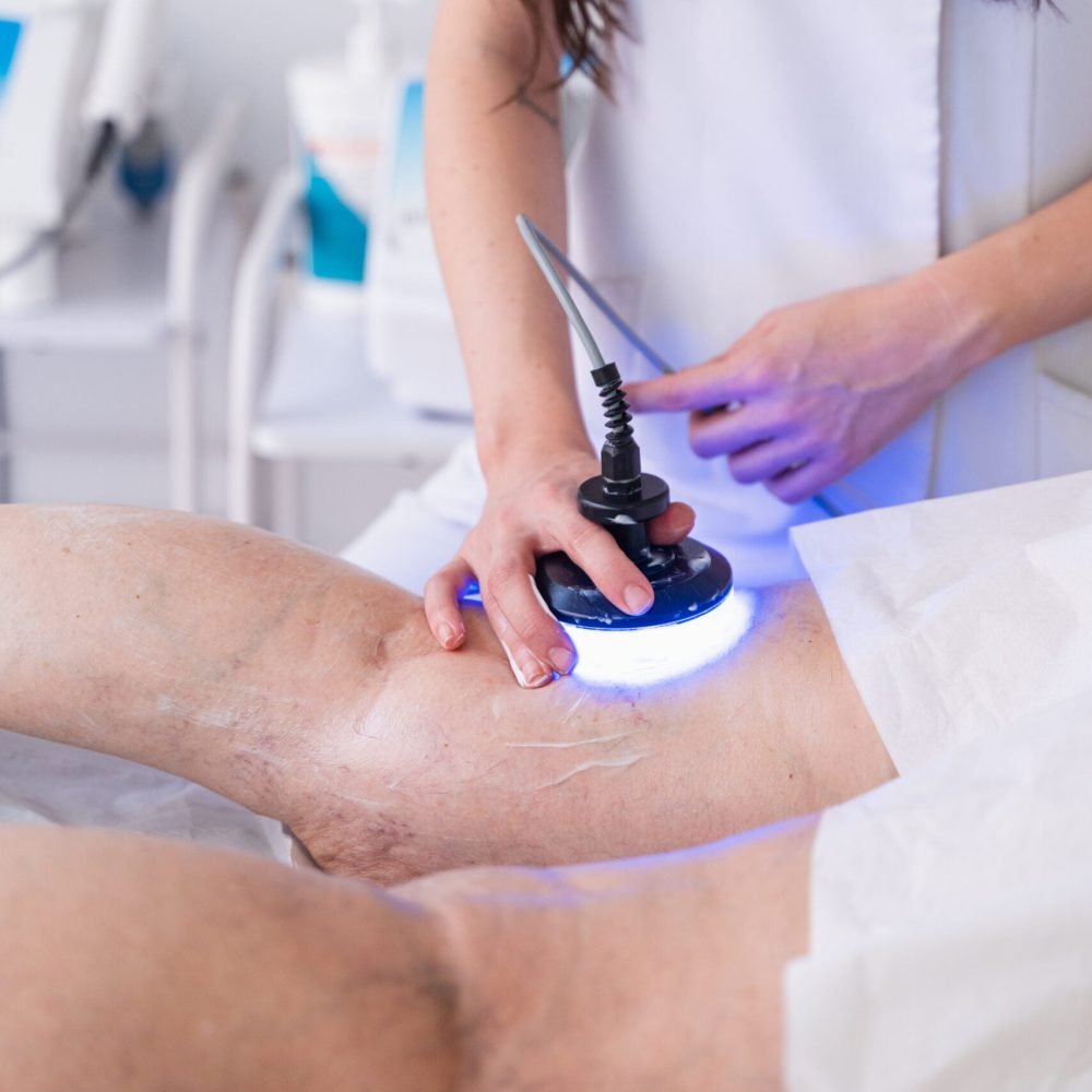 La fisioterapeuta Laura Bracero tratando la parte trasera de la rodilla de una paciente con diatermia.